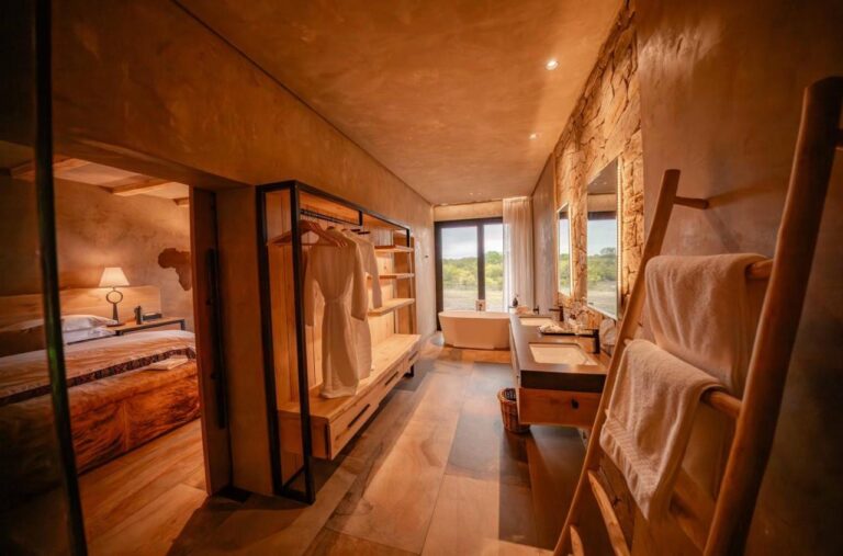Průchod do koupelny apartmá se šatní skříní, dvojitým umyvadlem a vanou