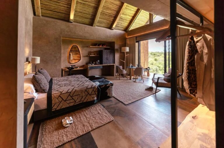 Apartmá Kapama River Lodge pod krovem ze dřeva a došků, s pracovním koutem a výhledem na stromy