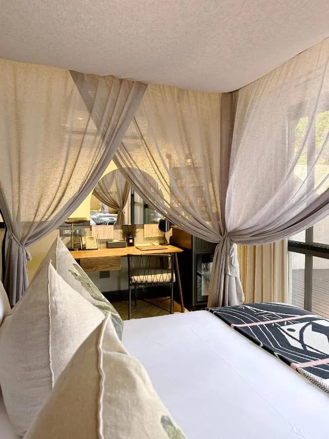 Pracovní kout v apartmá při pohledu z postele obklopené závoji