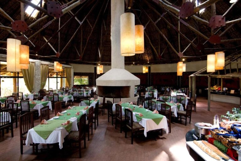 Jídelna restaurace kolem krbu uprostřed, s bufetem vpravo